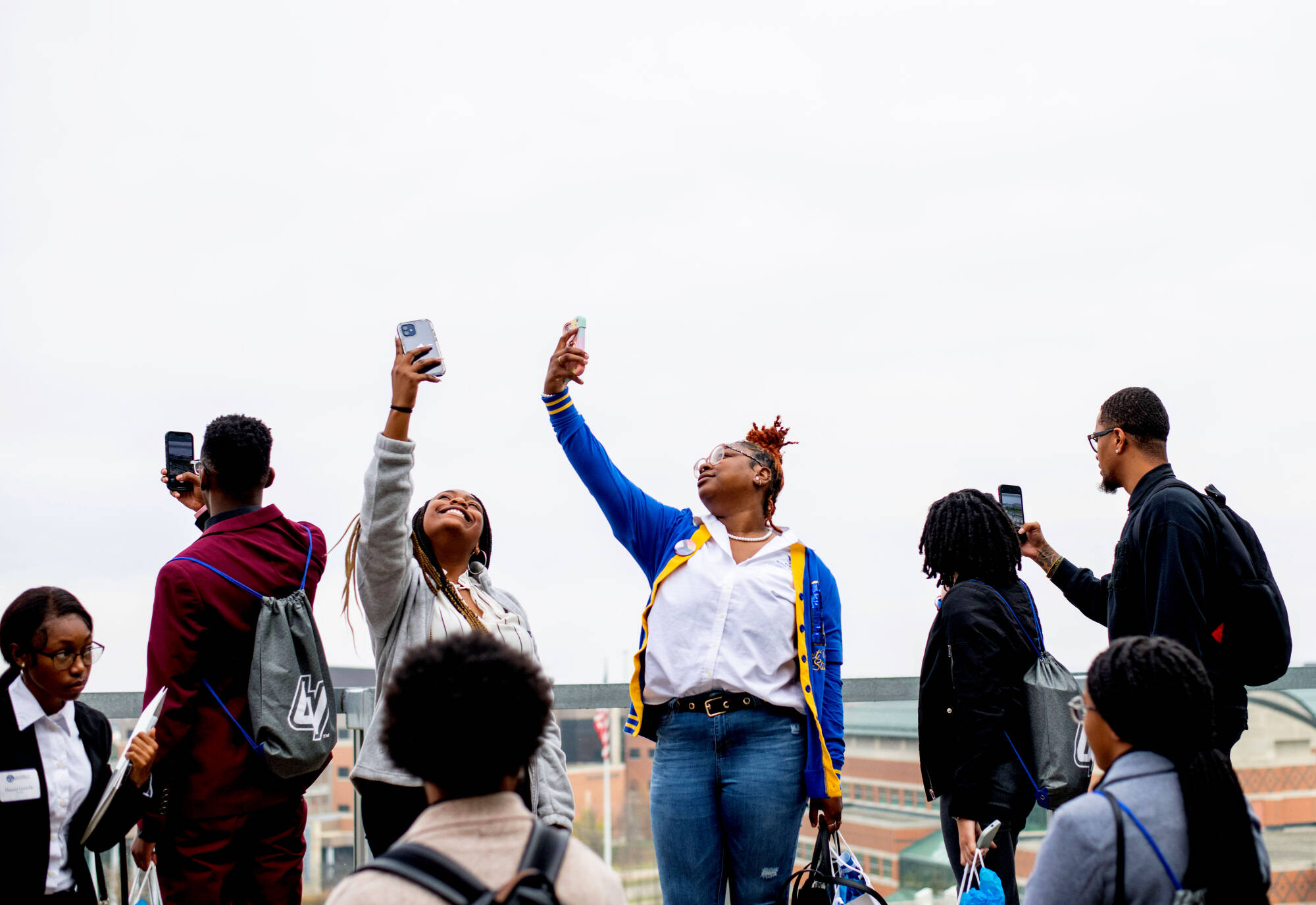 Kennedy McIntyre, left center, and Keyeria McCormick, right center, both of Fort Valley State University, take selfies from the fourth floor rooftop garden of the Mary Idema Pew Library while touring GVSU Oct. 31.